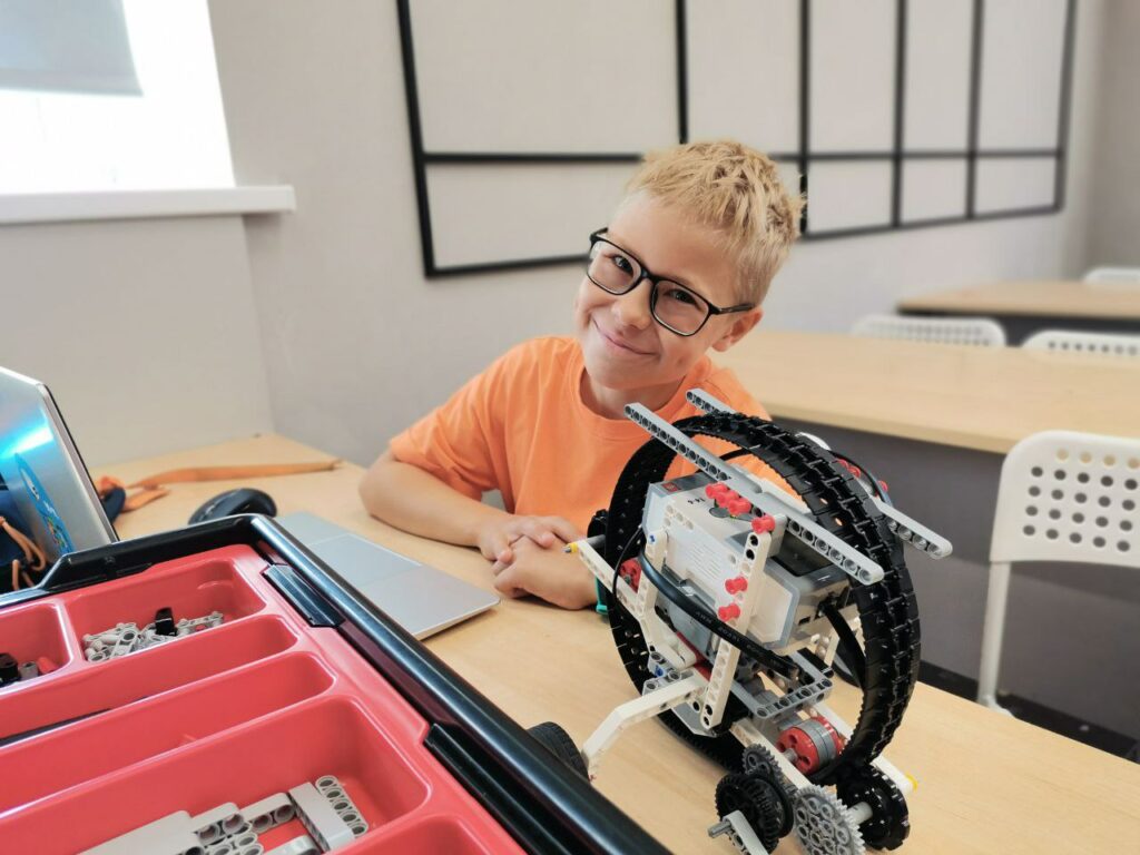 Мальчик на занятии по робототехнике с моделью робота из LEGO Mindstorms